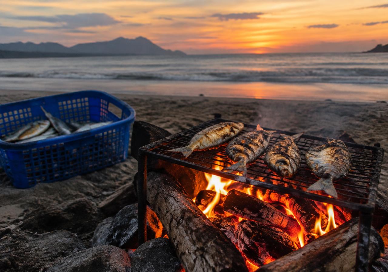 Fresh fish grilling over a beach campfire